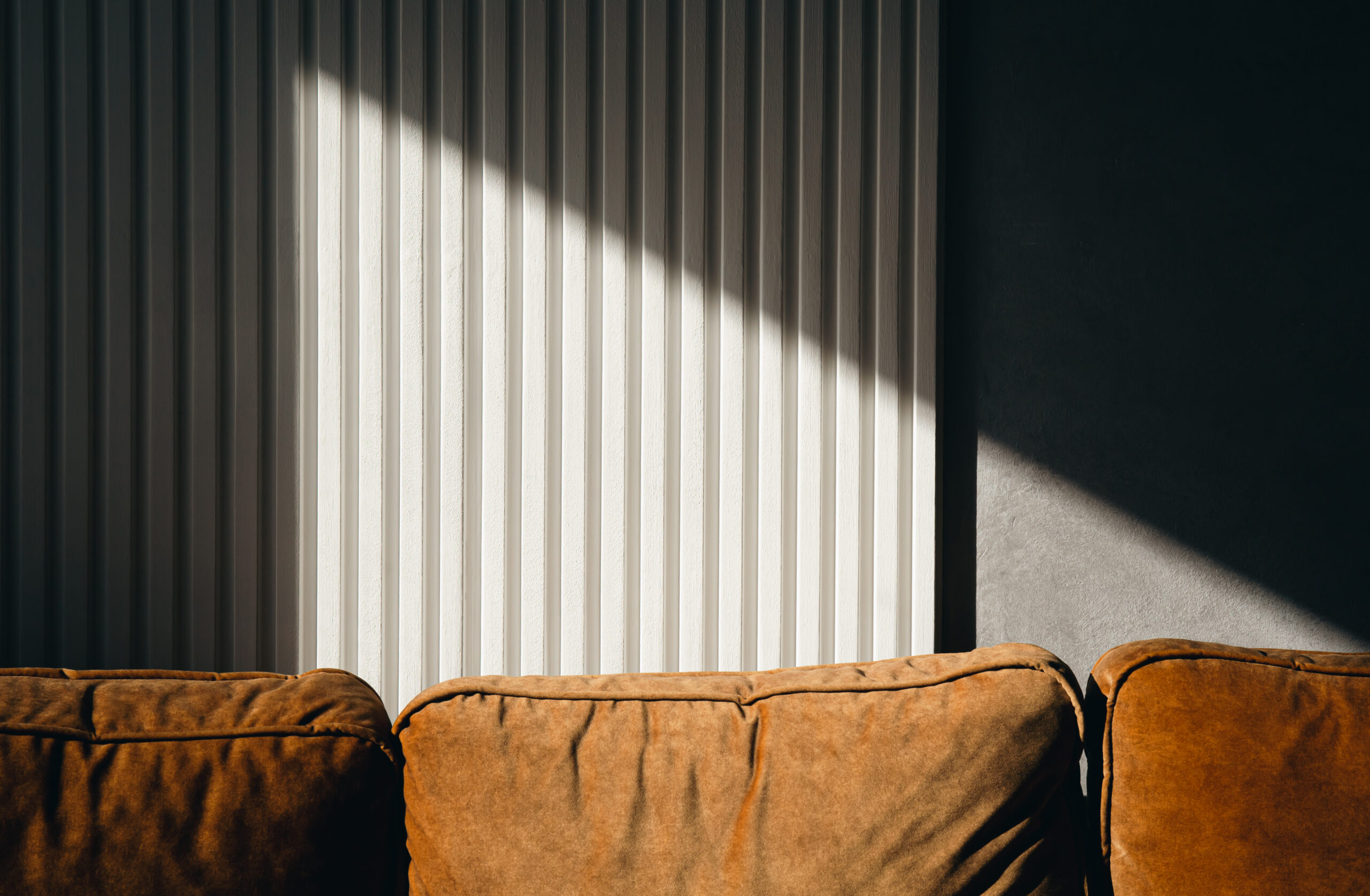 A ray of sun on a textured wall in a room.