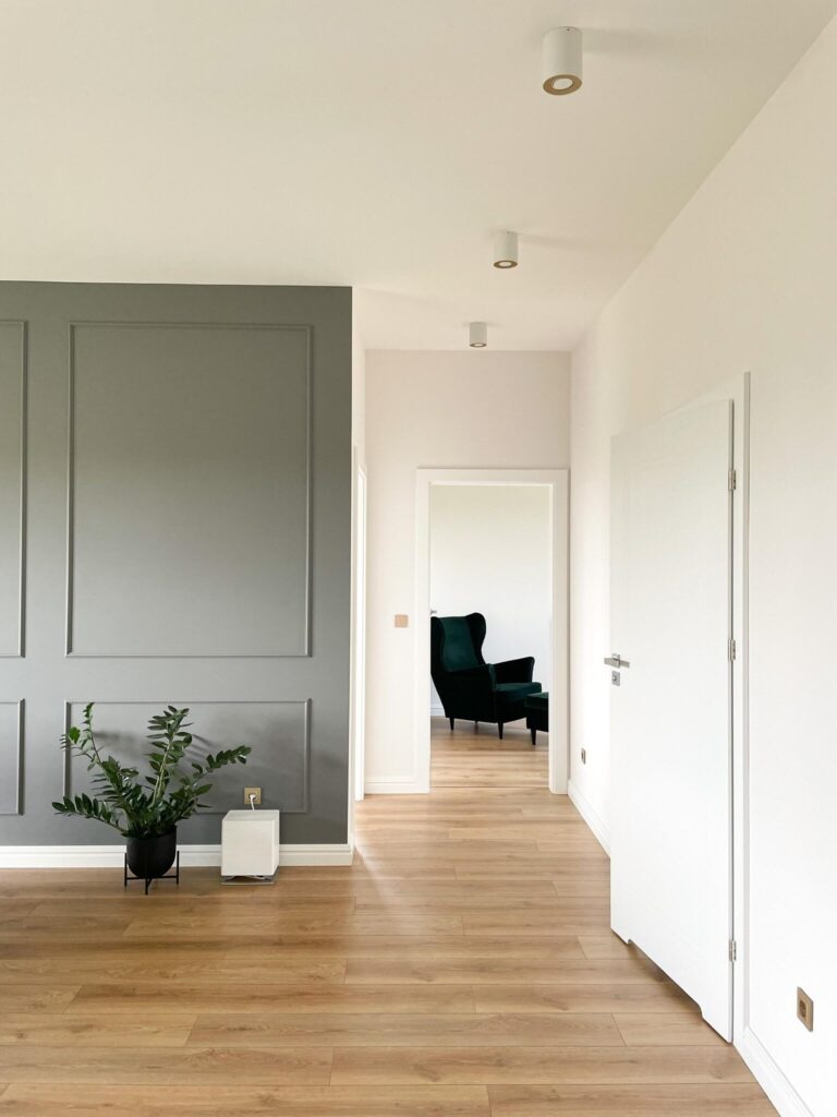 Bílý štukový nástěnný štuk MD413 Mardom Decor v minimalistickém uspořádání obývacího pokoje, malovaný v barvě stěny - neutrální šedá