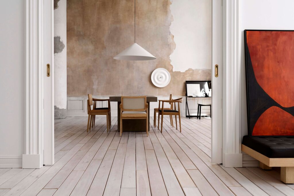 Aranżacja salonu w szarościach, bielach i beżach — przejście pomiędzy pokojami — pilastry w nowoczesnym designie jako obramowanie drzwi